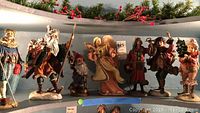 Front view of all seven figurines lined up on shelf
