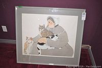 Full view of the framed print showing woman with three cats in muted colors, behind glass in gray frame.