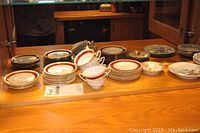 View of various china plates, saucers and teacups on wooden surface showing lot contents