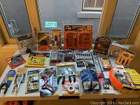 Photo showing the full lot of tools arranged on table, showcasing large variety of hand tools and accessories in packaging.