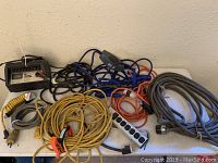 Overview of all cords and battery charger laid on a table showing their quantity and types.