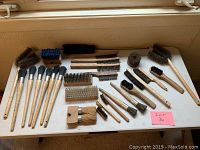 Top down view of entire lot showing all wire brushes arranged on a table.