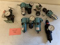 Six assorted regulator filters and pressure gauges arranged on a surface showing lot contents.