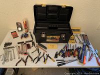 Full lot displayed on table showing Stanley tool box and assorted hand tools such as pliers, wrenches, screwdrivers, cutters, hammer, chisels, and measuring tools.