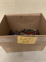 Cardboard box labeled Lot 64 containing a variety of drill bits and accessories