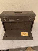 Front view of dusty vintage metal Remline toolbox with its six drawers and locking latches visible. Lack of key noted.