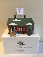 Front view of Department 56 Pennsylvania Dutch Barn figurine on top of original foam box with visible snow on green roof and silo.