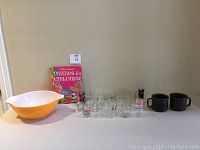Full lot showing Pyrex mixing bowl, shot glasses, Arabia mugs, and Betty Crocker book