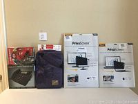 Photo shows all items in the lot lined up against a neutral wall: Diamond One Touch Video Capture VC500 sealed box, RCA ViSYS speakerphone box, two Fellowes PrivaScreen Blackout Privacy Filters for 20" and 17" screens, and purple Golla Bags laptop bag in protective sleeve.
