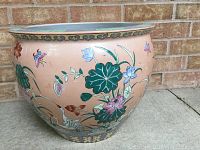 Front and side view of the planter showing floral exterior with raised and hand-painted flowers and cranes on a peach background.