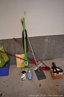 Wide shot showing two H2O X5 mops with cleaning attachments and various cleaning supplies on concrete floor.