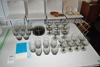 Overview of lot showing tumblers, stemware, and plates on table