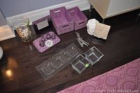 Overview photo of lot showing storage boxes, tray, wind chimes, statues, picture frame and glass vase with seashells