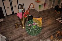 Photo of parasols, umbrella, Rumtopf urn and brass umbrella stand arranged on floor