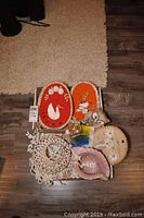 Lot of various shell and bird-themed decorative items, including pink ceramic shell planter, two oval bird art plaques, ceramic owl figurines, circular seashell chandelier, colorful tile, and round seashell display