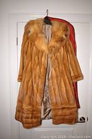 Front view of vintage fur coat showing natural fox and mink fur with golden-brown tones and visible plush texture.