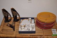 Miniature china tea set in box, West German pottery vases, vintage sectioned fondue plates, and stack of ceramic plates.