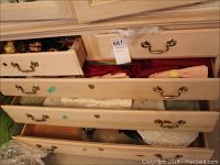Wooden drawers partially open showing folded table linens and napkins in various colors and styles.
