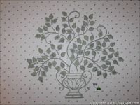 Full view of metal wall art showing symmetrical branches with leaves growing from an urn, against patterned wallpaper.