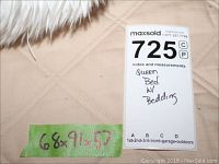 Close-up of mattress surface with green tape showing dimensions 68×91×57" and MaxSold tag 725