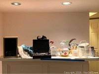 Wide view showing multiple items including bar set in box, tea cup planter, turkey planter, glassware, and air purifier on a counter surface.
