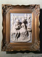 Front view of framed 3D porcelain relief depicting courting couple in Rococo style with ornate gilt frame.
