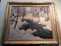 Frontal view of framed oil painting depicting winter landscape with open water