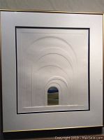Front view of the framed artwork featuring embossed arches and central colored landscape image.