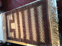 Full top-down view of the entire rug laid on table with measuring tape