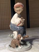Front view of Lladro figurine showing boy sitting on white stump with puppy in front
