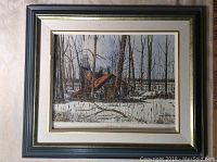 Framed hand-coloured print showing overall framed art with winter scene of a sugar shack and snow-covered ground.