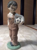 Front view of Lladro figurine showing boy holding soccer ball, detailed facial expression, and colored overalls