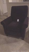 Front angled view of the purple recliner chair showing the padded backrest, armrests, and seat cushion on a carpeted floor.