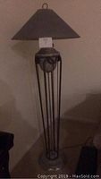Full view of the tall grey floor lamp with conical shade and visible chipped base detail.