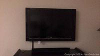 42 inch Vizion flat screen TV with sound bar on a stand.