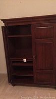 Front view of the closed cabinet showing the dark wood finish and paneled doors.