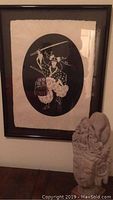 The photo shows a framed black and white ink print of a Japanese samurai in full costume with a sword, hanging on a wall.