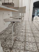 Four matching chairs in a row beside kitchen island showing overall set and style