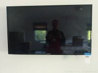 Front view of the Samsung 42-inch TV mounted on the wall, showing black flat panel screen with Samsung logo in the center bottom bezel.
