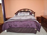 Full front view of queen size bed with bedding and pillows, showcasing headboard