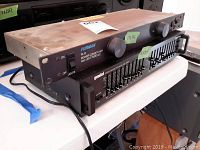 Side view of Furman PL-8 power conditioner stacked on top of Gemini EQ-2001 graphic equalizer showing multiple slider controls and front panel details.