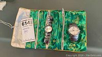 Both watches displayed in green jewelry pouch