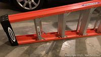 Photo showing the bright orange Werner ladder with aluminum construction and black end caps with Werner logo.