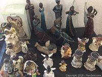 Overview of assorted Black American figurines and sculptures on display, showing diversity in size, posture, and themes.