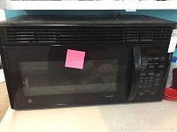 Front view of black GE Spacemaker microwave with door and control panel, showing digital buttons and numeric keypad