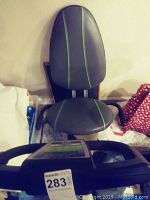 View of the padded seat and ergonomic backrest, black with green stripes.