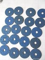 Top-down view of 20 blue circular meat ration tokens from WWII Canada, showing embossed text and central hole.