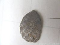 Obverse side of the small silver coin showing worn details, partial inscriptions visible.