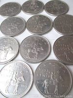 Eleven 1973 Canadian quarters showing RCMP design on the reverse side