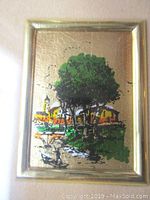 Close-up of the lithograph artwork featuring a green tree and surrounding park elements over a gold leaf background.